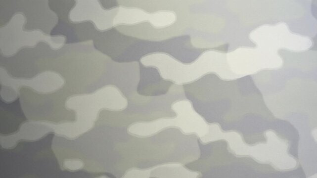 Panning shot of camouflage pattern on fabric shifting slowly across seamless backdrop on studio set closeup, neutral gray tones