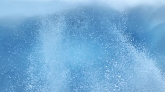 Slow motion close up of wave spray crashing and rising on ocean surface offshore seascape with frothy white foam and misty water motion