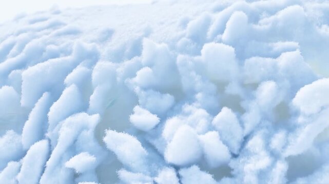 Slow motion close up pan of snowflakes settling and accumulating on snowy surface in cold outdoor winter landscape morning