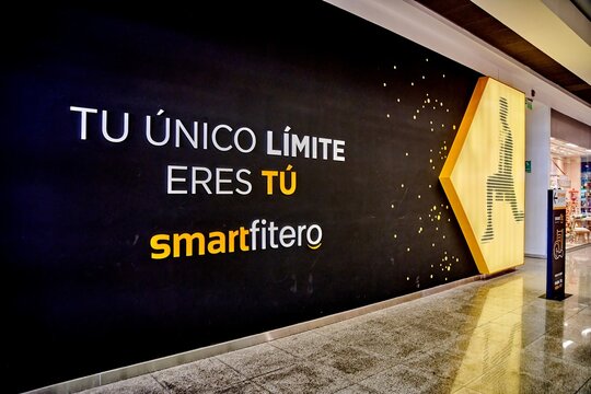 Ambato, Ecuador - October 28, 2025: Smart Fit fitness club wall mural featuring motivational text and logo in a modern gym environment with bright lighting and polished floor