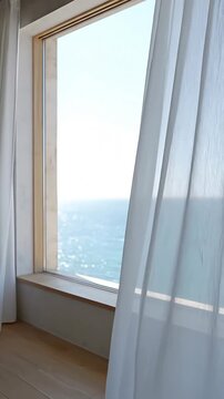 A panoramic view through a bright, minimalist window offering a mesmerizing look at a calm ocean, creating a tranquil atmosphere with billowing curtains.