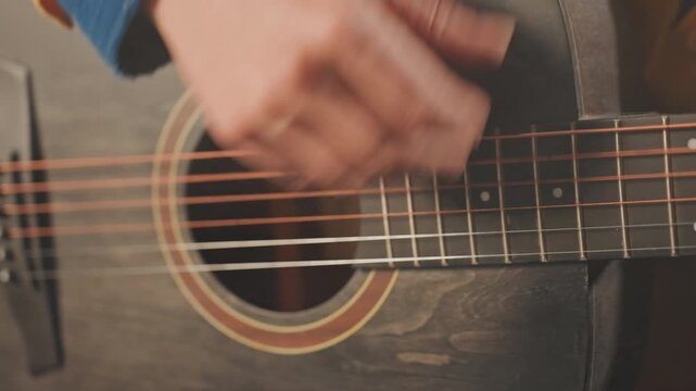 Guitar technique overview. Closeup on string plucking methods. Detailed view of fret hand movements and strum pattern. Intimate shot highlighting chord changes and finger positioning techniques