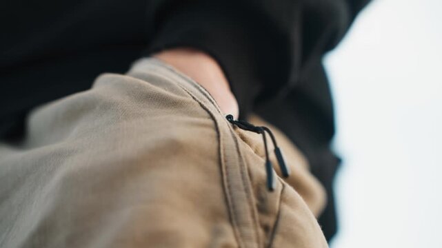 Detailed mechanical focus. Precision work with careful attention. Hands meticulously adjusting zipper with deliberate care. Precise hand operates small device with focused intent and skill