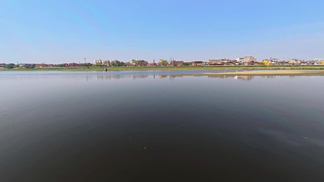Indian jamuna scenic view of a river with a cityscape on the horizon 4k stock time lapse video footage.