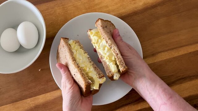 Eating a Egg Salad Sandwich on Wheat Bread