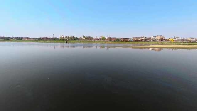 Indian jamuna scenic view of a river with a cityscape on the horizon 4k stock slow motion  video footage.