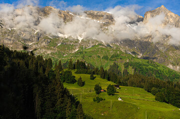 Fototapeta premium Majestic Alpine Peaks and Lush Green Slopes Above Engelberg Village 
