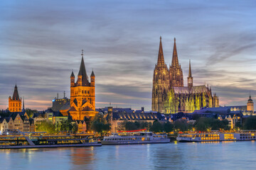 Obraz premium Cologne historical center with cathedral and Saint Martin view at evening from Rhine in Germany. Illuminated city architecture