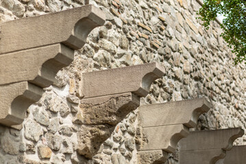 Stone wall with decorative corbels and shadows © Mirko