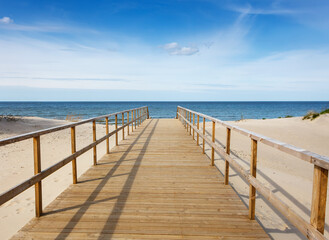 Fototapeta premium Wooden footpath going through a sand dune to the Baltic Sea