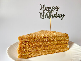 a piece of delicious cake on a white plate on a white background, happy birthday greetings © Polina_mrtnk
