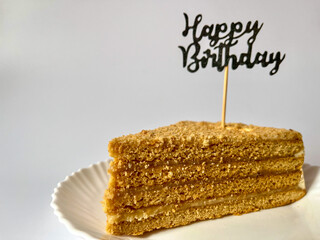 a piece of delicious cake on a white plate on a white background, happy birthday greetings © Polina_mrtnk