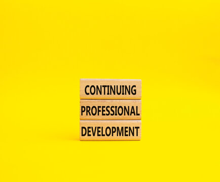 Continuing Development symbol. Concept words Continuing Professional Development on wooden blocks. Beautiful yellow background. Business and Development concept. Copy space