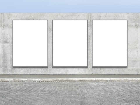 Three large vertical white advertising boards are placed on the facade of a concrete fence, intended for creative use. Presentation space. Advertising space.