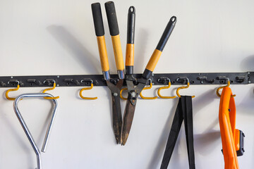 Gardening tools hanging from a garage wall storage organizing hook