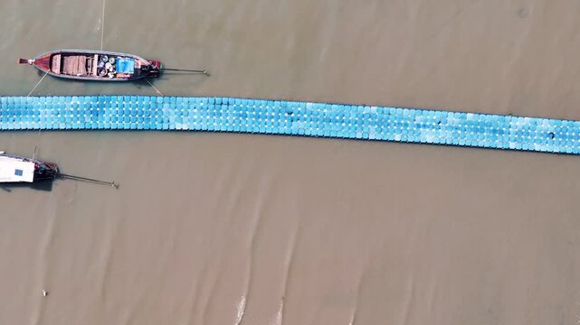 Top down aerial turquoise sea water texture and fishing boats on dock in Phuket Thailand