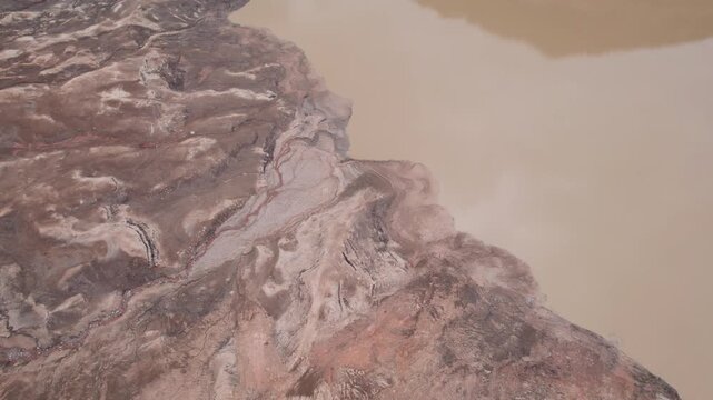 Abstract textures on the drained reservoir floor at Vidraru Dam with mineral patterns and sediment layers	