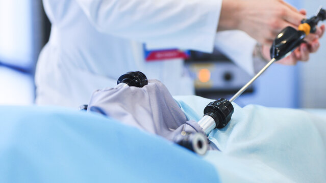 Surgeon performing laparoscopic operation in operating room using medical equipment