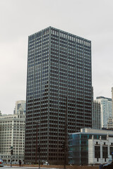 Obraz premium Modern office building stands tall in a busy city center during an overcast day