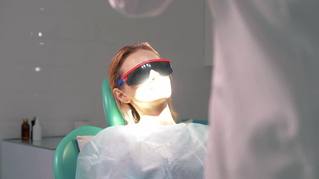 Beautiful girl in dark glasses at a reception in a dental clinic