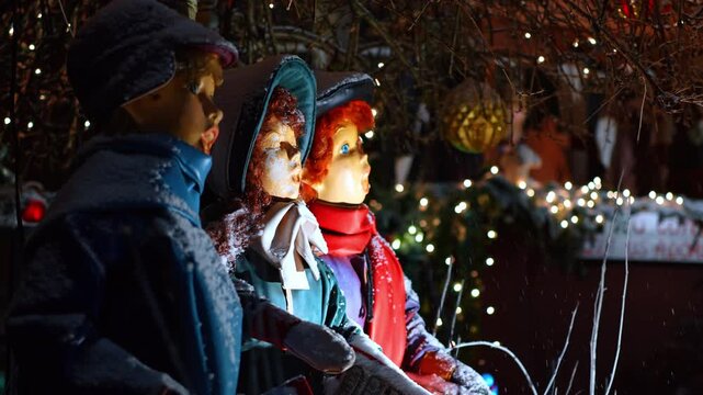 Side view of three Christmas caroler figures in winter clothing. Close-up profile of holiday singers with snow dusting and warm bokeh lights in New York.