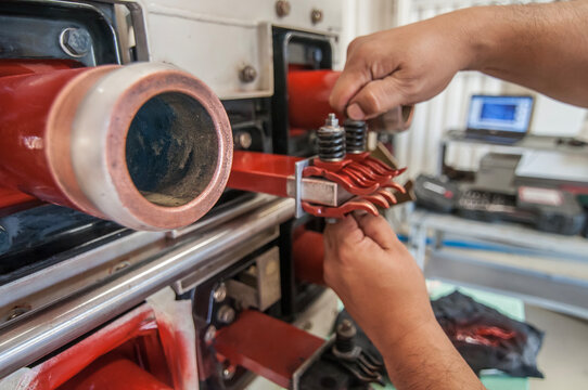 Tecnico electrico en trabajps de mantenimiento a conexiones de interruptores 480 volts con barras de bus de tablero