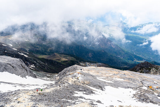 Clouds drifting over snowy alpine mountains and a deep valley