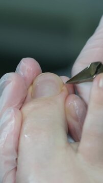 A man cuts toe nail using a nail clipper. Foot and toes of an adult man, close-up shot. High quality 4k footage