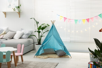 Child's room with furniture, toy wigwam and colorful flags. Interior design © New Africa