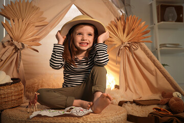 Little girl with drawing of map near wigwam at home © New Africa
