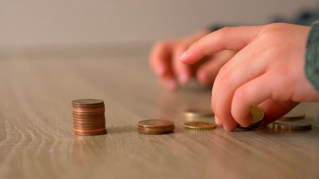 Child Hands Sorting Euro and Cent Coins into Groups by Denomination on Wooden Table &mdash; Euro Currency, Money Sorting, Financial Literacy and Early Numeracy Concept