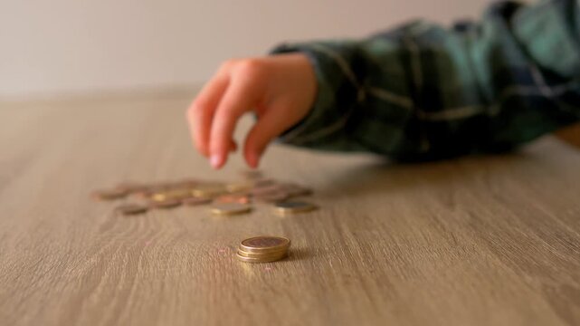 Child Hand Sorting and Stacking Euro Coins on Wooden Table &mdash; Euro Currency, Child Financial Literacy, Money Sorting and Savings Habit Concept