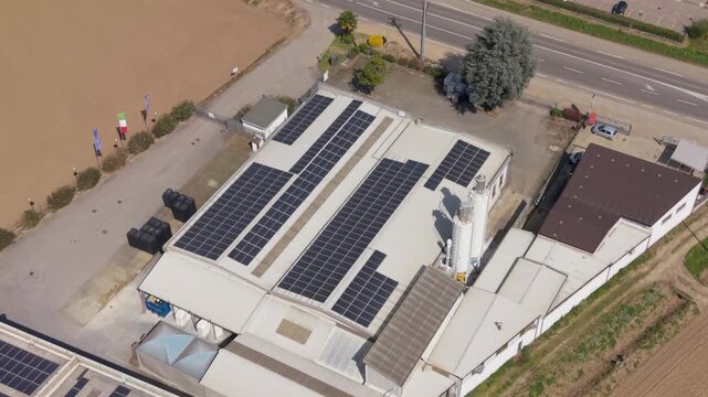 Sustainable Energy Initiative: An expansive rooftop array of solar panels atop a modern industrial facility underscores a commitment to sustainable energy practices.
