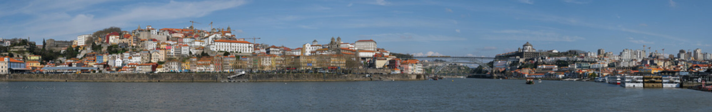 Panoramic view of Porto riverside cityscape with colorful houses and historic architecture by Douro river
