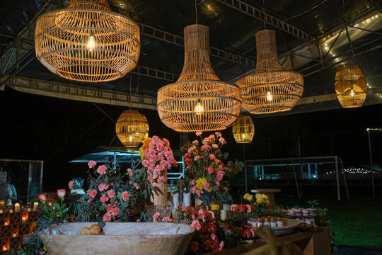 Woven rattan pendant lamps illuminating a luxury outdoor event