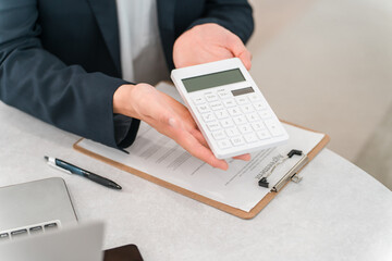 Obraz premium A male businessman's hands as he displays numbers on a calculator.