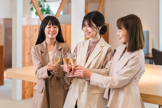 Businesswomen lining up in the office with champagne (teamwork, pep rally, victory celebration, celebration)