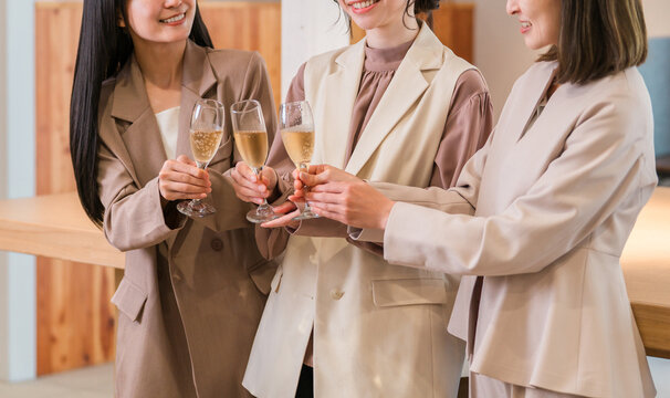 Businesswomen lining up in the office with champagne (teamwork, pep rally, victory celebration, celebration)