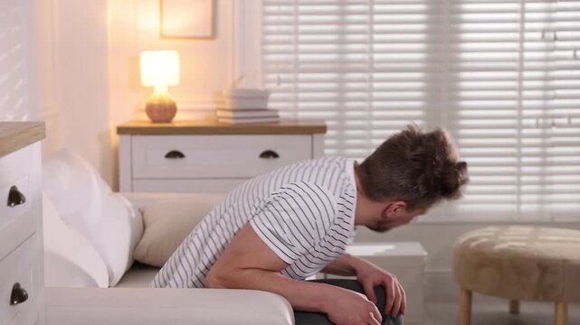 Man suffering from panic attack on sofa at home