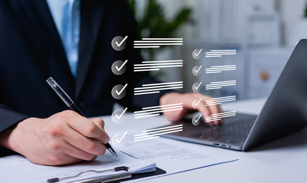 Businessman reviewing electronic files on laptop and compare with document paper utilizing intelligent management system to validate records and streamline final approvals, quality assurance concept.