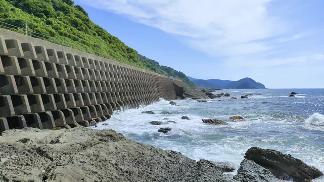 日本海の庄内海岸でコンクリートブロックに打ち寄せる波の風景
