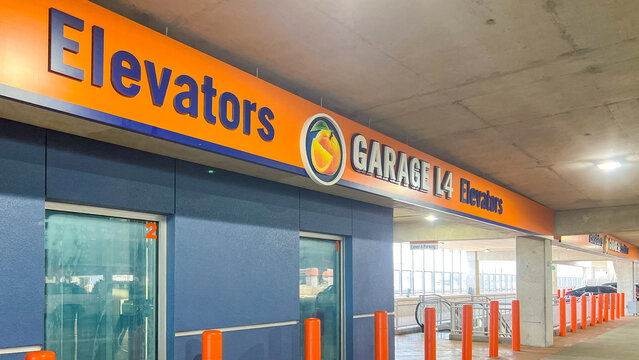 Disney Springs parking garage sign indicating elevators and Garage L4, featuring bright orange and blue colors in a modern architectural design