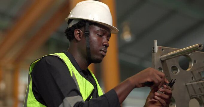 Factory technician uses a vernier caliper to measure a metal component during dimensional inspection in a manufacturing facility, showing quality control, tolerance checks, and process verification.
