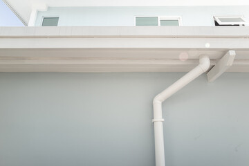 Architectural view of modern contemporary building featuring rain gutter system with white PVC...
