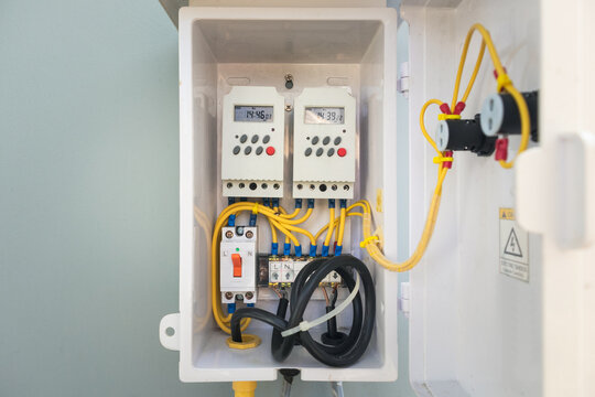 Electrical panel control box revealing wiring, circuit breakers and timer control unit. Timer or clock control allows scheduled switching, enabling automatic on off functions and energy management.