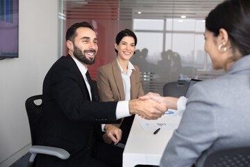 Plakat Smiling male executive and female partners exchanging professional handshake, as business partnership agreement, closing commercial deal, finalizing successfully corporate meeting. Collaboration