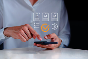Business using smartphone with digital checklist, quality assurance icons, and ISO compliance symbol, representing audit process, certification standards, workflow validation corporate management