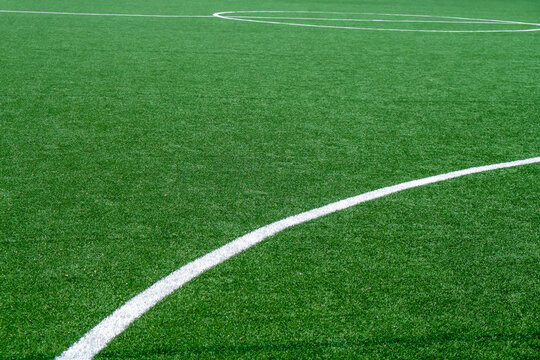 Soccer field with green grass and white line, sport background.