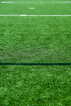 Soccer field with green grass and white line, sport background.