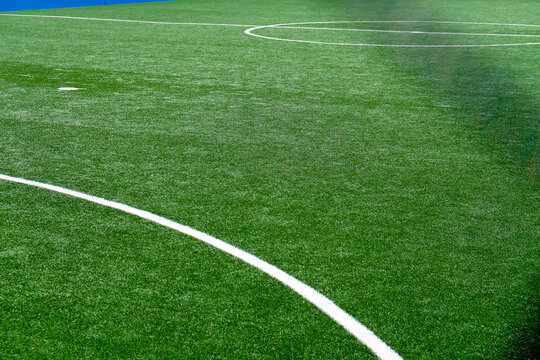 Soccer field with green grass and white line, sport background.